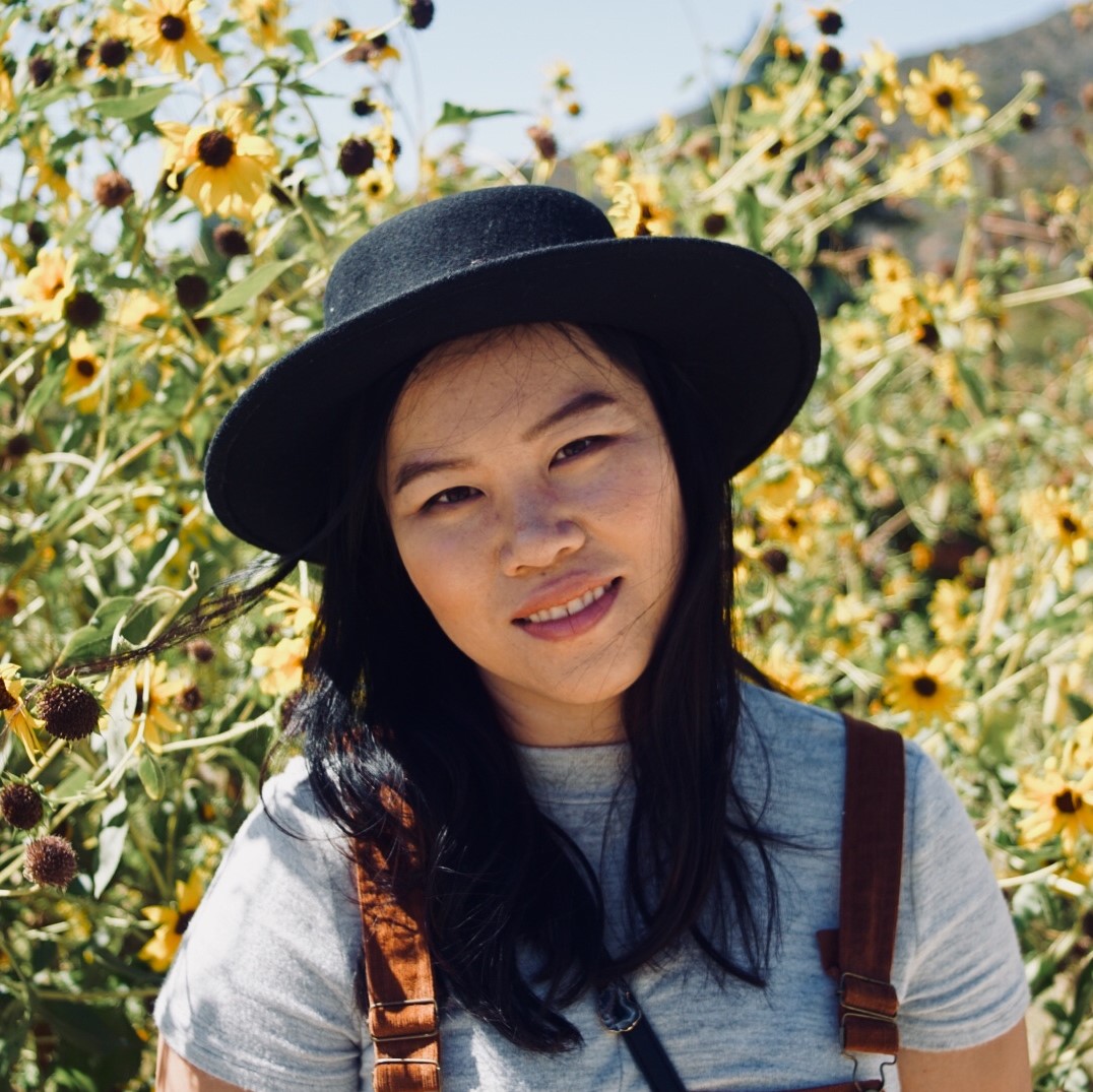 diana luong standing in front of a sunflower field. 
